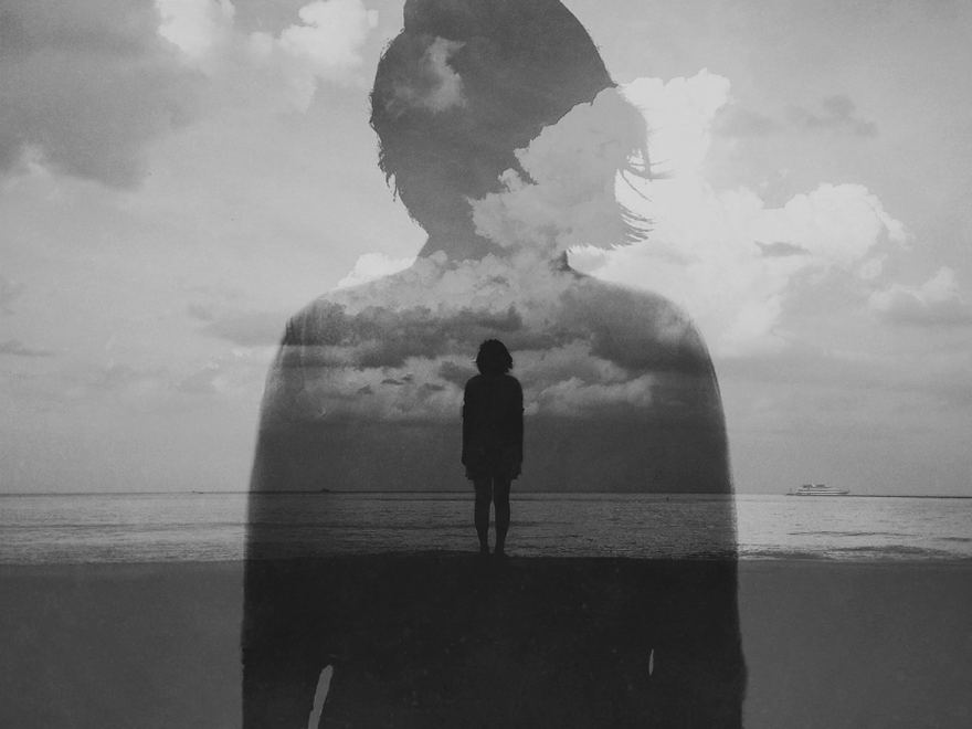 Silhouette eines Menschen, in der sich Meer und Himmel spiegeln
